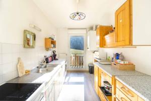 a kitchen with wooden cabinets and a sink at Bel appartement à la montagne in Séez