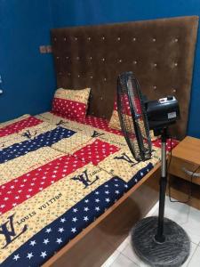 a room with a bed with a fan on it at MAVINIK'S (Ogun State) HOTEL, SUITES AND LOUNGE in Otta