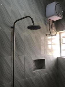 a shower with a shower head in a bathroom at MAVINIK'S (Ogun State) HOTEL, SUITES AND LOUNGE in Otta