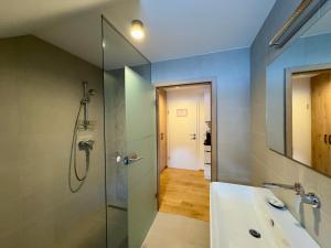 a bathroom with a shower and a sink and a mirror at Apartmaji Kotnik in Kranjska Gora