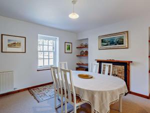 a dining room with a table and chairs and a fireplace at 1 Bed in Alness CA015 in Boath