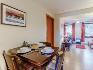 - une salle à manger avec une table et des chaises en bois dans l'établissement 1 Bed in Badachro CA357, à Strath