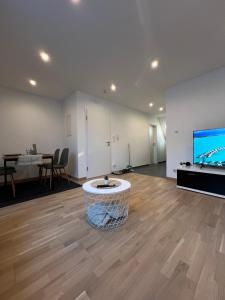 a living room with a table and a flat screen tv at Moderne Wohnung Karlsruhe Neureut in Karlsruhe