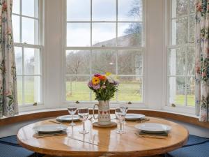 a table with a vase of flowers and glasses at 2 Bed in Applecross CA422 in Applecross