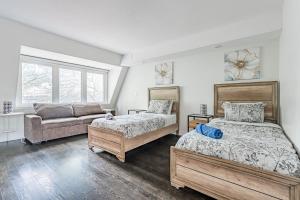 um quarto com 2 camas e um sofá em Luxury properties close to Eaton Center! em Toronto