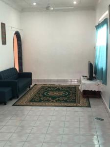 uma sala de estar com um sofá e um tapete em Easah Homestay Malacca em Malaca