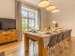 a dining room with a table with chairs and a television at 5 Bed in Bude 77823 in Bradworthy