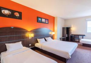 a hotel room with two beds and an orange wall at B&B HOTEL Agen Castelculier in Castelculier