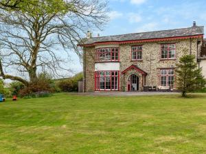 a large brick house with red windows and a yard at 5 Bed in Bude 77823 in Bradworthy