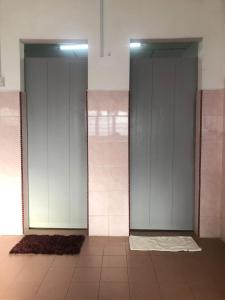 Duas portas de vidro num quarto com piso em azulejo em Easah Homestay Malacca em Malaca
