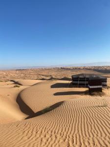 Clouds Desert Camp في Badīyah: صحراء مع مبنى في منتصفها