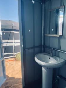 a blue bathroom with a sink and a window at Clouds Desert Camp in Badīyah