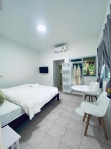 um quarto com uma cama, uma mesa e cadeiras em SLAV Naithon Boutique Hotel and Restaurant em Phuket