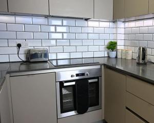 a kitchen with a stove top oven in a kitchen at Chic 1 Bedroom Flat in Bedford