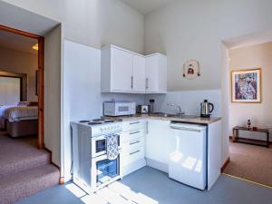 a kitchen with white cabinets and a stove top oven at 1 Bed in Alness CA232 in Boath