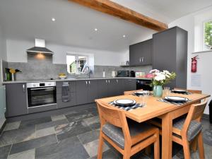 a kitchen with a wooden table and a stove at 2 Bed in Wrexham 76399 in Coedpoeth