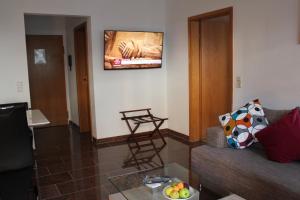 羅拉赫的住宿－費恩渥諾沃提尼酒店，客厅配有沙发和墙上的电视