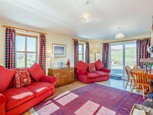 uma sala de estar com dois sofás vermelhos e uma mesa em 3 Bed in Ardvasar CA071 em Aird of Sleat