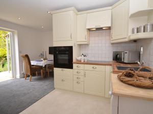een keuken met witte kasten en een eetkamer bij 1 Bed in Taunton 75135 in Isle Brewers