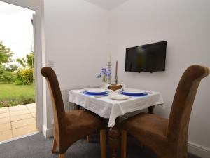 a dining room with a table with chairs and a tv at 1 Bed in Taunton 75135 in Isle Brewers