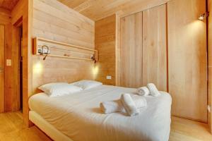 a bedroom with a large bed with towels on it at AUBERGE 1 in Morzine