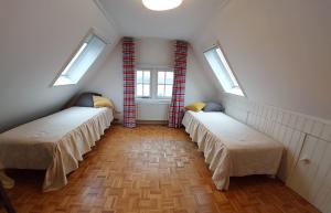 two beds in a room with two windows at Pakhuys bij de Zaanse Schans in Zaandijk
