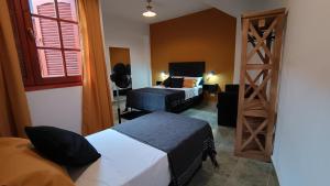 Habitación pequeña con 2 camas y escalera. en Hostería Suites Del Centro en Santa Rosa de Calamuchita