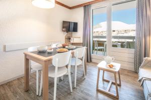 a kitchen and dining room with a table and chairs at Résidence Pierre & Vacances Les Bergers in L'Alpe-d'Huez