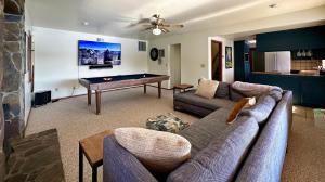 Una sala de estar con un sofá y una mesa de billar. en Luxury Yosemite Lake House, en Groveland