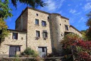 an old stone building with a tower at la Ferme de Vazerat in Massiac