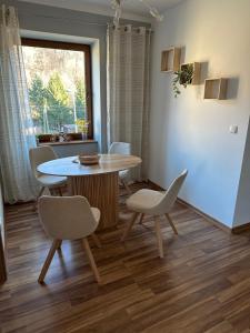 a dining room with a table and chairs and a window at Apartament Wałbrzych in Wałbrzych