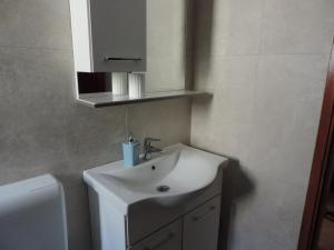 a bathroom with a white sink and a toilet at Apartmani Antica in Cres +23 photos
