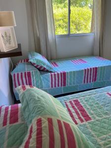 two beds sitting next to a window in a room at Firenze Cabañas - Playa Chapadmalal in Chapadmalal