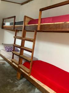 2 stapelbedden in een kamer met een rode matras bij Hostel Solar in Mucugê