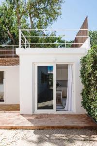 Casa blanca con una gran puerta de cristal en Hoso Loft 24 Beach House en Costa da Caparica
