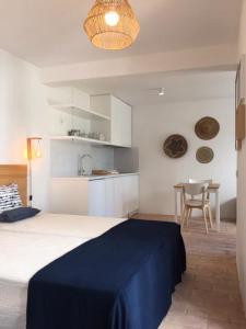 um quarto com uma cama e uma cozinha com uma mesa em Hoso Loft 24 Beach House em Costa da Caparica
