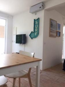 ein Esszimmer mit einem Tisch und einem Schild an der Wand in der Unterkunft Hoso Loft 24 Beach House in Costa da Caparica