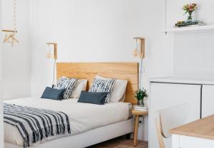 a bedroom with a white bed with blue pillows at Hoso Loft 24 Beach House in Costa da Caparica