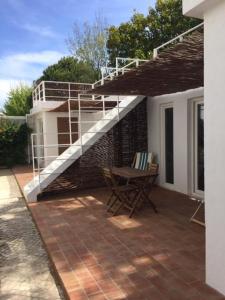 un patio con escalera, mesa y silla en Hoso Loft 24 Beach House en Costa da Caparica