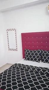 - une chambre avec un lit noir et blanc et un miroir dans l'établissement Residence Sighaka - Premium VIP Apartment - WiFi, Gardien, Parking, à Douala