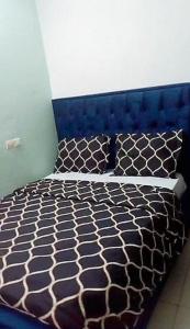 - un lit bleu avec une couette noire et blanche dans l'établissement Residence Sighaka - Premium VIP Apartment - WiFi, Gardien, Parking, à Douala