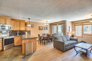 a kitchen and living room with a couch and a table at Ski-InandSki-Out Winter Park Condo with Mountain Views in Winter Park