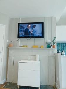 a flat screen tv on a wall above a fireplace at Yukos-Studio Cosy-(Hypercentre) in Rennes