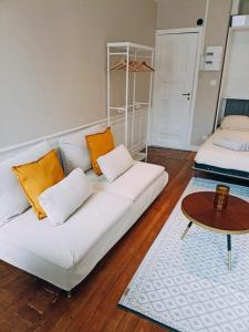 a living room with a white couch and a table at Yukos-Studio Cosy-(Hypercentre) in Rennes
