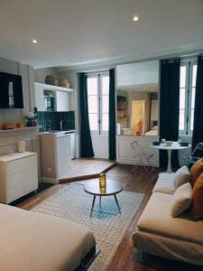 a living room with a couch and a table and a kitchen at Yukos-Studio Cosy-(Hypercentre) in Rennes