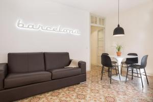 a living room with a couch and a table and chairs at Ola Living Santa Anna in Barcelona