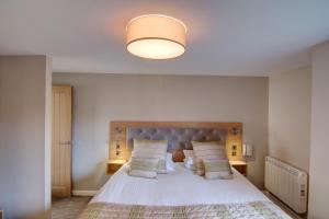 Schlafzimmer mit einem großen weißen Bett mit blauem Kopfteil in der Unterkunft China Fleet Country Club in Saltash