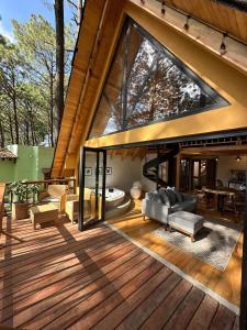 een open terras met een woonkamer met een groot raam bij Cabañas VIP Mazamitla in Mazamitla