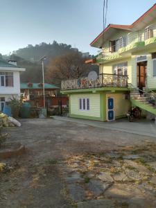 Una casa amarilla con balcón en la parte superior. en Akash Homestay en Shimla