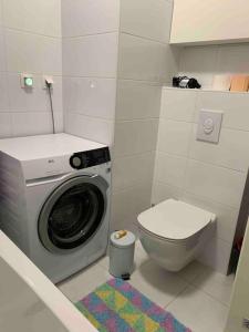 a bathroom with a washing machine and a toilet at Close to center big terrace city tram garage parking place fast WIFI Super king size bed grocery 1min in Zagreb